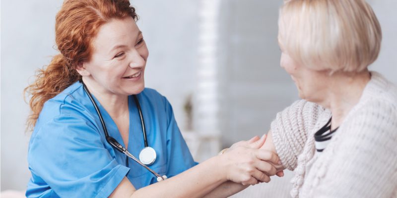 Photograph showing a nurse taking a patients blood pressure.