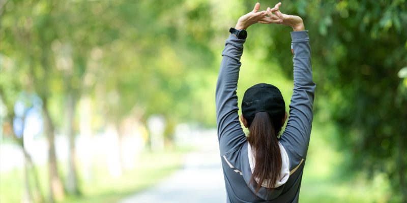 A person outdoors who is stretching 