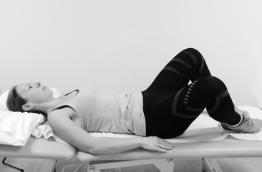 Laid on back with knees bent. One knee slowly bending out to the side