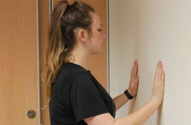 Person stood with both hands against a wall