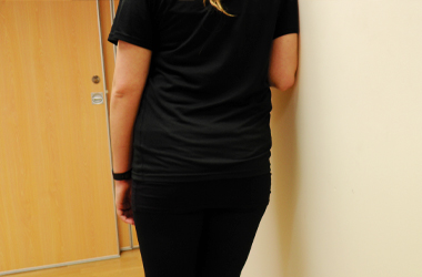 Upper arm is placed against a wall