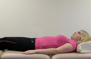 Laying on your back, affected arm resting at your side