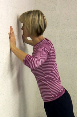 Bending your arms to bring your head towards the wall