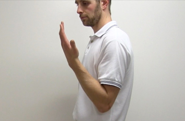 Elbow is bent with hand toward the face
