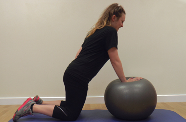 Affected arm only on the ball with the body moving slowly forwards toward the ball
