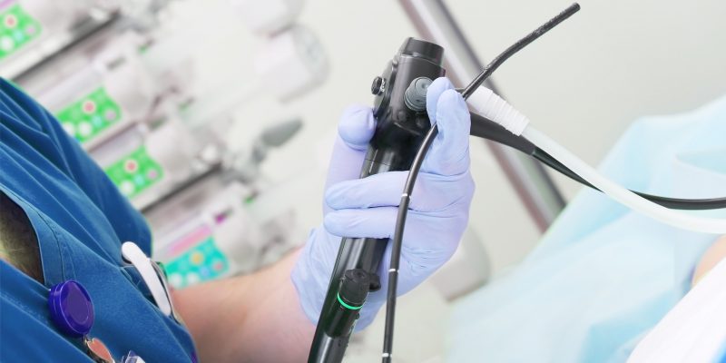 Closeup image of a medical professional preparing to perform an examination of the colon