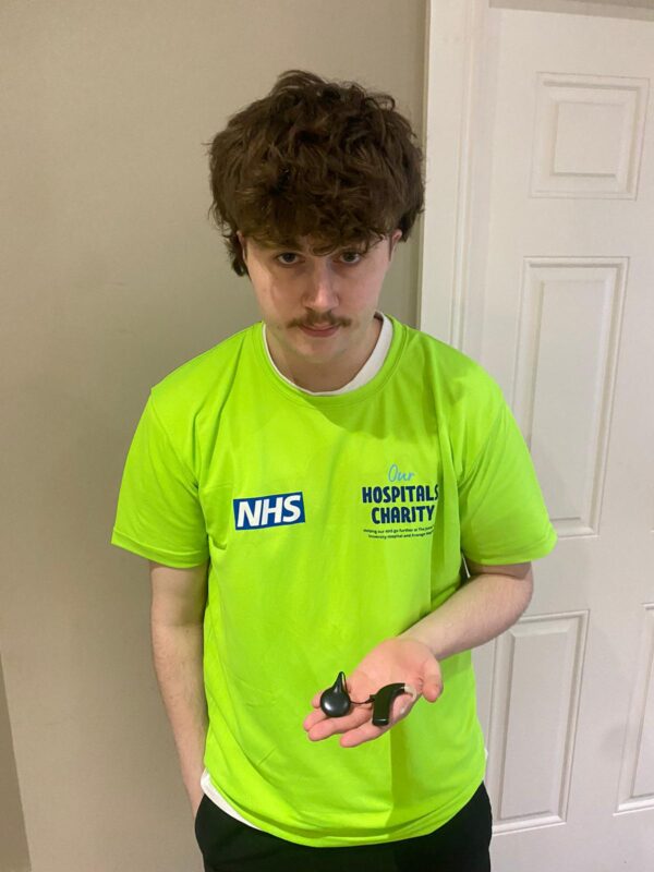 Jake Bishop displaying his cochlear implant device