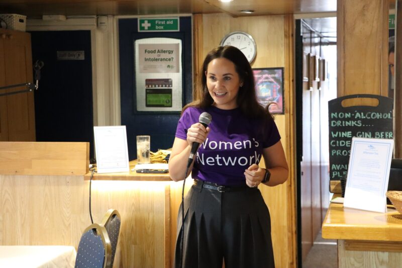a woman with a mic presenting
