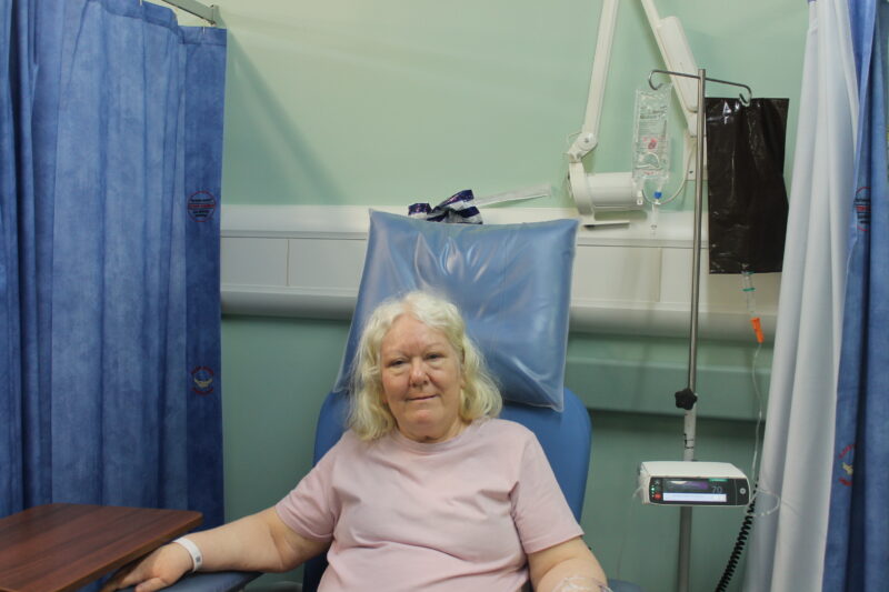 a patient sat on a bed on a ward 