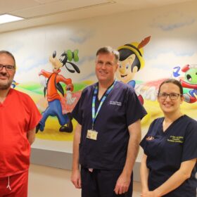 Bruce Jaffray, David Macafee, and Amy Norrington in the children’s theatre corridor at James Cook