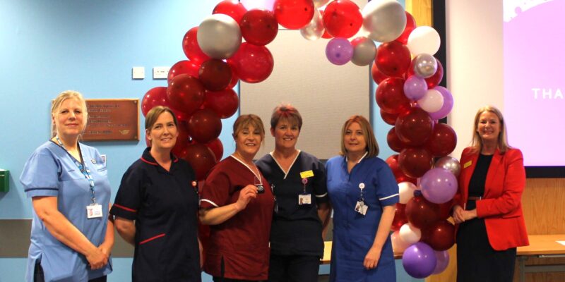A group of people stood in front of a balloon arch