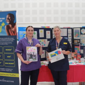 Two people holding up magazines