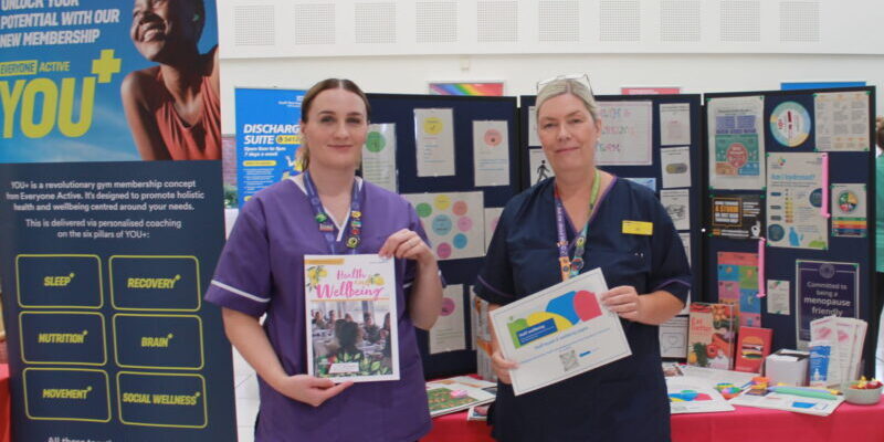 Two people holding up magazines